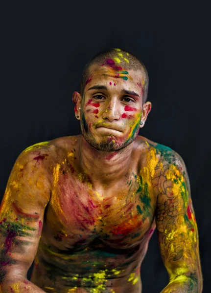 Handsome young man with skin all painted with Holi colors