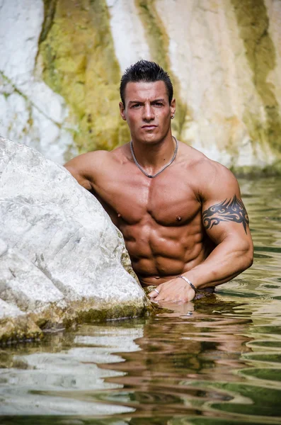 Handsome young muscle man in water pond