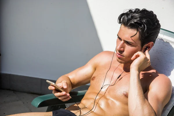 Young Man Listening to Music on Lounge Chair