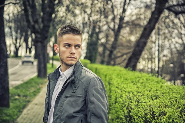 Handsome young man looking at camera in park