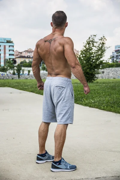 Back of Muscular Shirtless Hunk Man Outdoor in City Setting