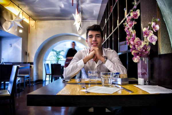 Handsome young man having lunch in elegant restaurant