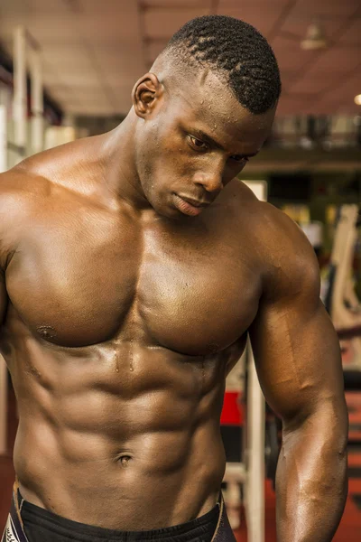 Black male bodybuilder resting after workout