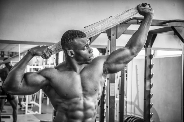 Attractive hunky black male bodybuilder in gym