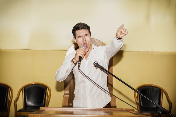 Passionate Man Speaking into Microphone in Meeting