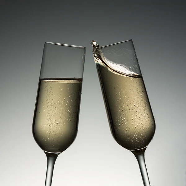 Clink glasses with champagne splash