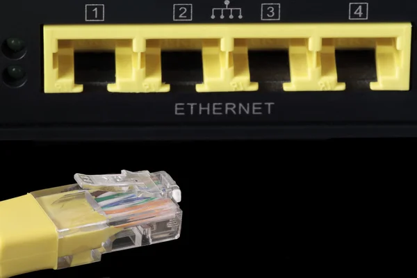 Foreground of a yellow network cable and four network ports at t