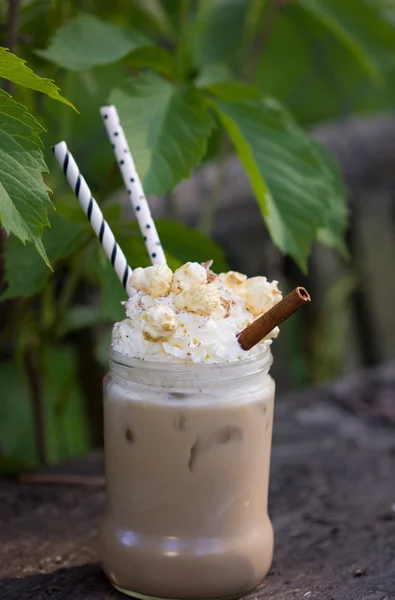 Iced coffee with whipped cream caramel popcorn and cinnamon
