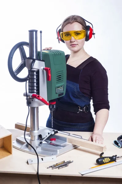 Female carpenter and drilling machine.