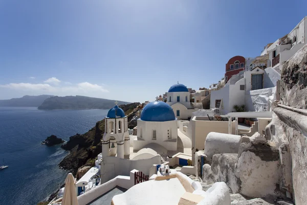 A small white Greek Orthodox church with a typical blue roof on the cliff in Oia (Ia), Santorini island, Cyclades Greece