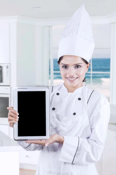 Chef holds digital tablet in kitchen