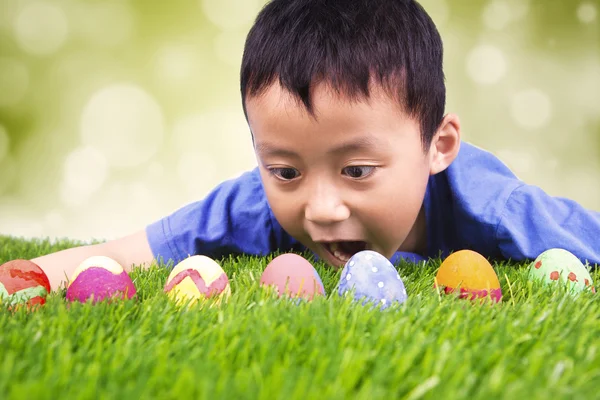Little boy finding easter eggs on grass
