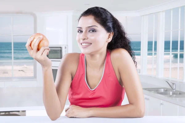 Indian model holds apple in kitchen