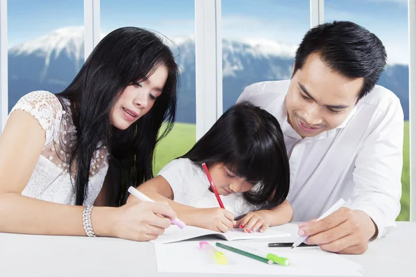 Father and mother help their child for studying