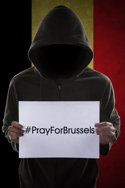 Person holds text to pray for Brussels