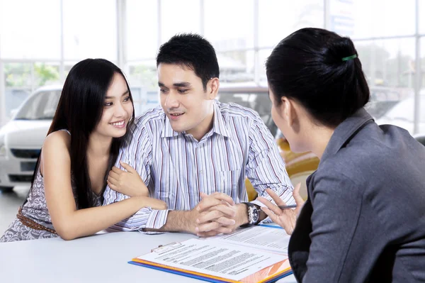 Car buyers discussing with car dealer