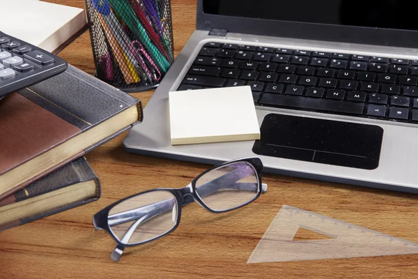 Laptop with glasses and stationery