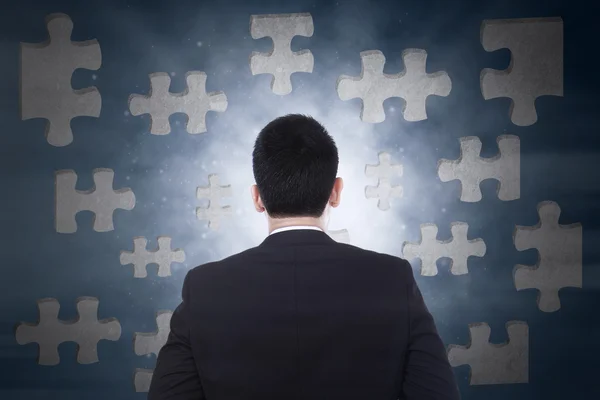 Businessman looking at puzzle