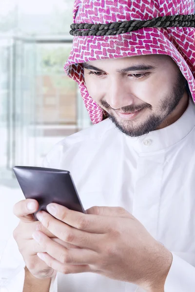 Arabic man sending message in office