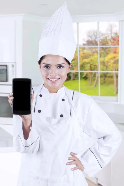 Chef showing smartphone in the kitchen
