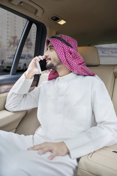 Arabian person talking on the phone in car