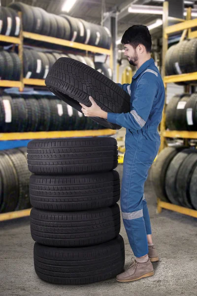 Arabian mechanic pile up tires in workshop