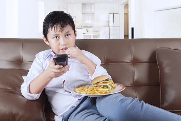 Male kid enjoy fast food at home
