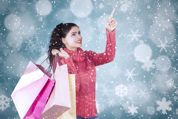 Woman with shopping bags and winter background