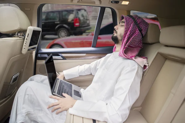 Arabian man with laptop resting in car