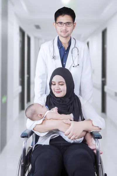 Male doctor with patient and her baby