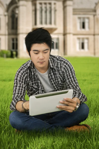 Casual male student with tablet at park