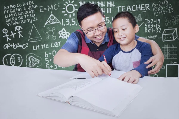 Teacher guide a little boy to learn