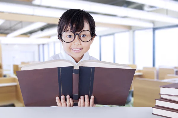 Schoolgirl reads science books on desk