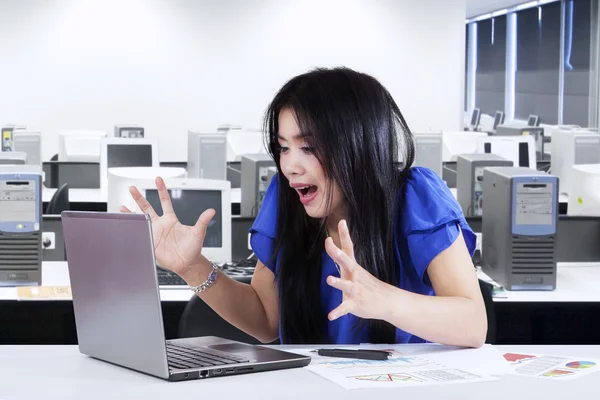 Shocked woman with notebook in office