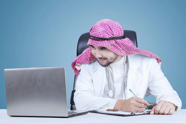 Middle eastern doctor looking at the laptop