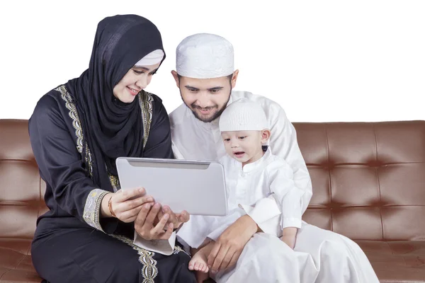 Arabian family use tablet on sofa