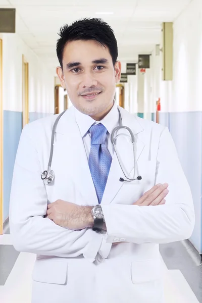 Doctor smiling in hospital corridor