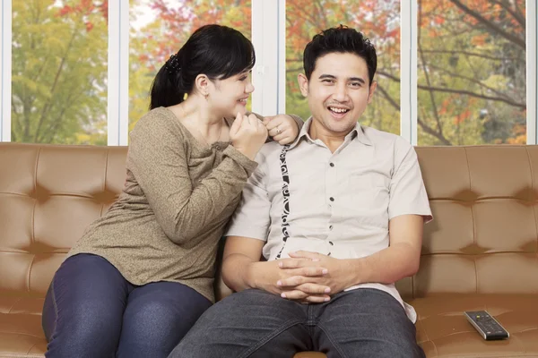 Happy Asian couple on a couch at home