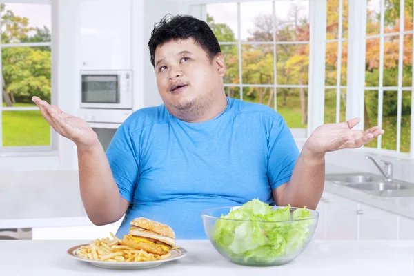 Overweight person thinks to choose meal