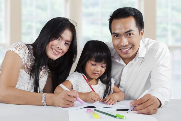 Cheerful parents help their child studying