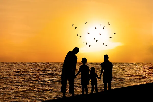 Silhouette of happy family on beach 1