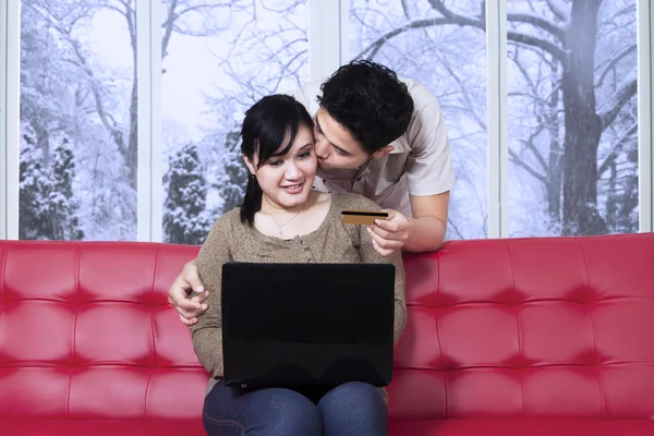 Man kissing her wife while pay online