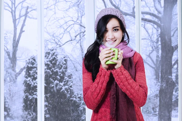 Young lady wearing sweater enjoy warm drink