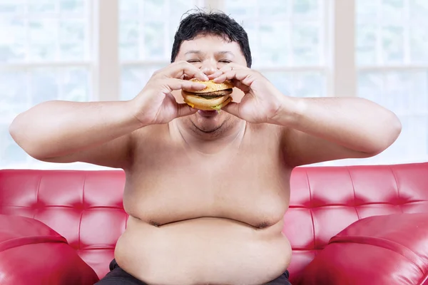 Fat man eating hamburger