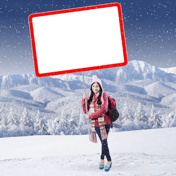 Schoolgirl with billboard at mountain