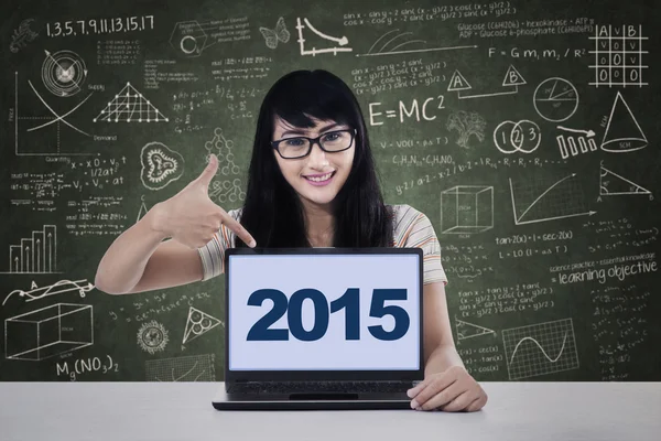 Student pointing numbers 2015 on laptop
