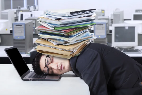 Frustrated man with document sleeping in office