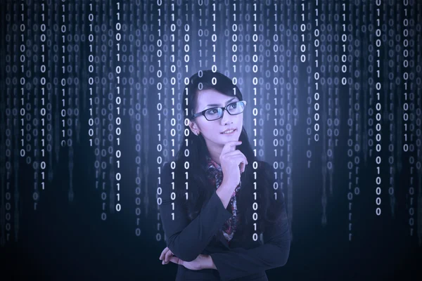 Businesswoman looking at binary code