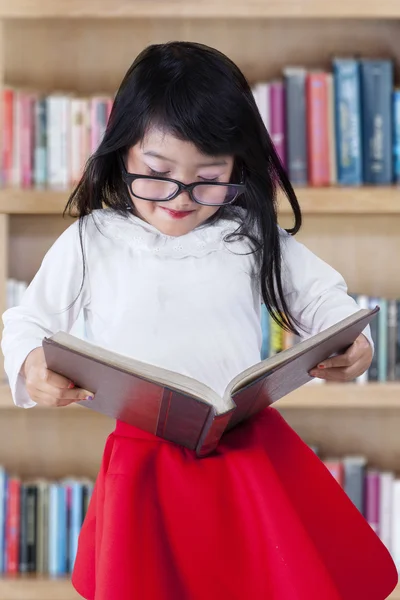 Lovely girl holding a book in library