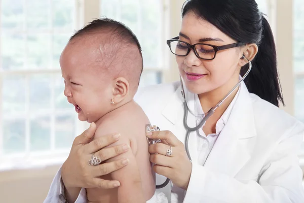 Young doctor checking little baby
